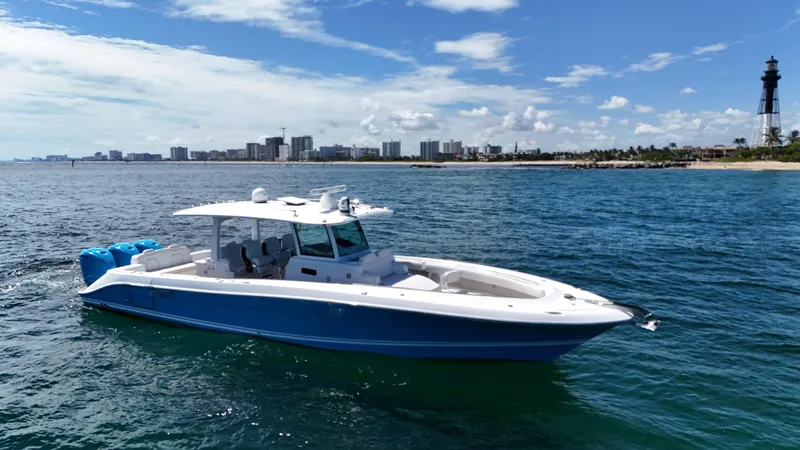  Yacht Photos Pics 2022 HCB Lujo boat on ocean near city skyline and lighthouse.