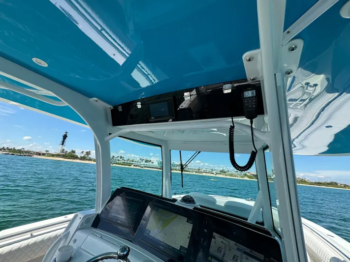  Yacht Photos Pics Interior view of 2022 HCB Lujo boat with navigation equipment, overlooking ocean and lighthouse.