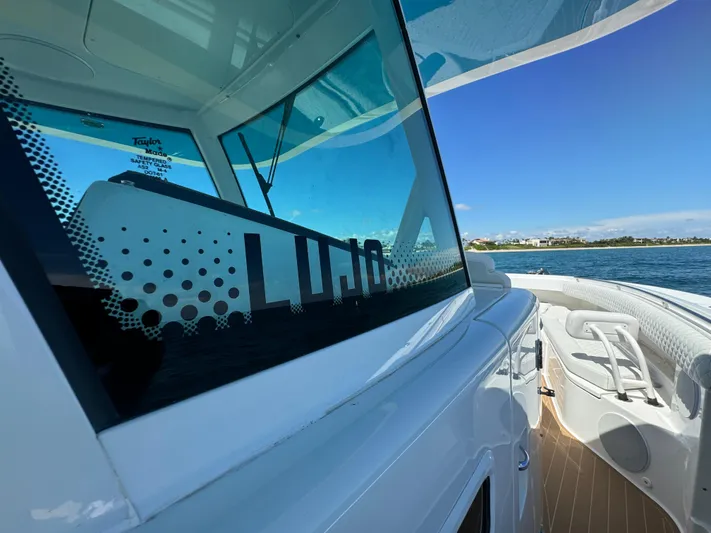  Yacht Photos Pics 2022 HCB Lujo boat with sleek design, docked by the water under a clear blue sky.