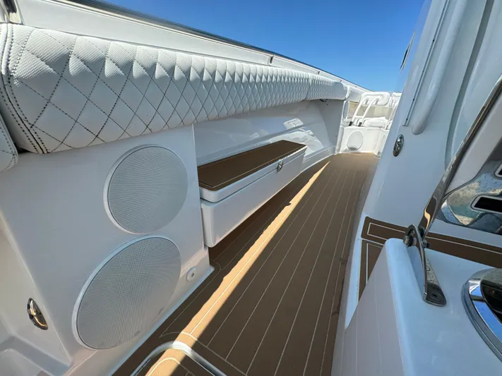  Yacht Photos Pics 2022 HCB Lujo boat interior with cushioned seating, speakers, and teak flooring.