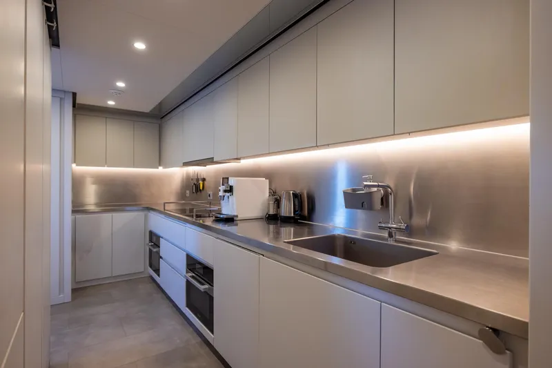 Stellamar Yacht Photos Pics Modern yacht kitchen with sleek stainless steel countertops, appliances, and under-cabinet lighting, 2023 Cantiere Delle Marche RJ 115.