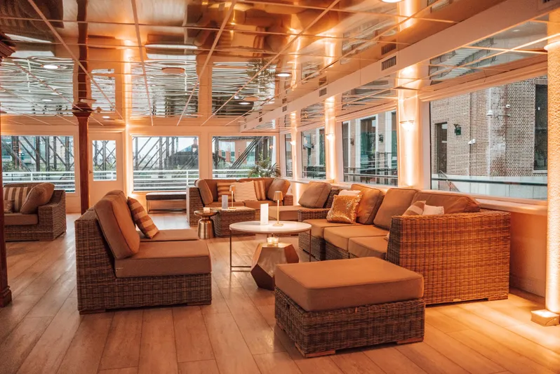 Sir Winston Yacht Photos Pics Luxurious interior of a 2007 custom passenger vessel with elegant wicker seating and warm lighting.