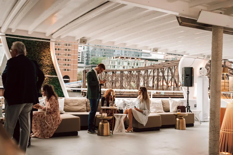 Sir Winston Yacht Photos Pics Luxurious passenger vessel interior with guests, modern decor, and cityscape view.