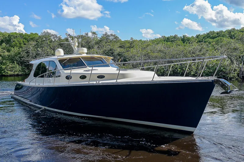 Pb45 2017 Yacht Photos Pics 2017 Palm Beach Motor Yachts PB45 cruising on a serene waterway under a blue sky.