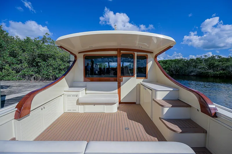 Pb45 2017 Yacht Photos Pics 2017 Palm Beach Motor Yachts PB45, elegant deck with seating, under a clear blue sky.