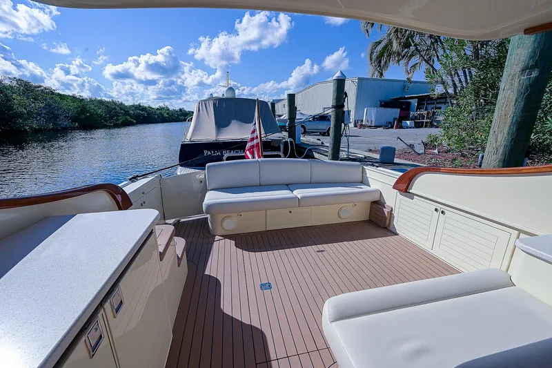 Pb45 2017 Yacht Photos Pics 2017 Palm Beach Motor Yachts PB45, spacious deck with seating, docked by a scenic waterfront.