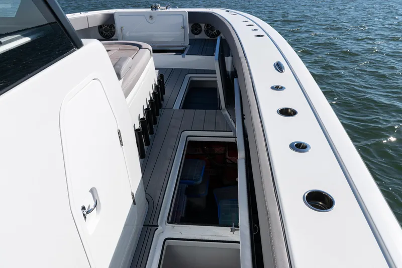  Yacht Photos Pics 2024 Freeman 47 boat deck with storage compartments, rod holders, and seating on open water.