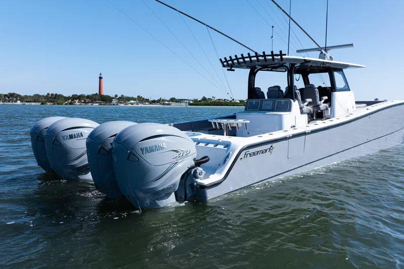  Yacht Photos Pics 2024 Freeman 47 boat with Yamaha engines on water, lighthouse in background.