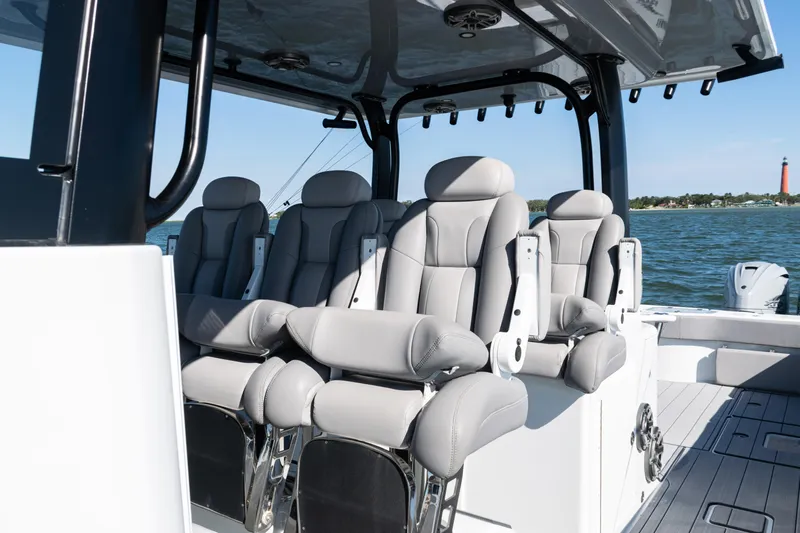  Yacht Photos Pics Luxurious seating on 2024 Freeman 47 boat with ocean view and lighthouse in background.