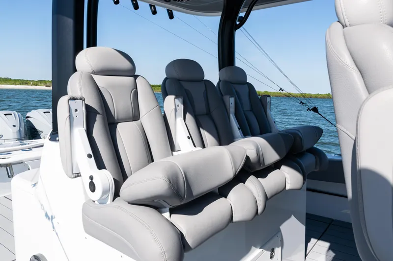  Yacht Photos Pics Luxurious seating on 2024 Freeman 47 boat, featuring plush gray upholstery and ocean backdrop.