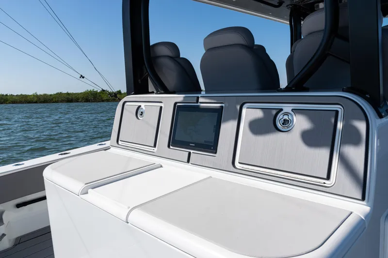  Yacht Photos Pics 2024 Freeman 47 boat console with navigation screen and storage compartments on calm water.