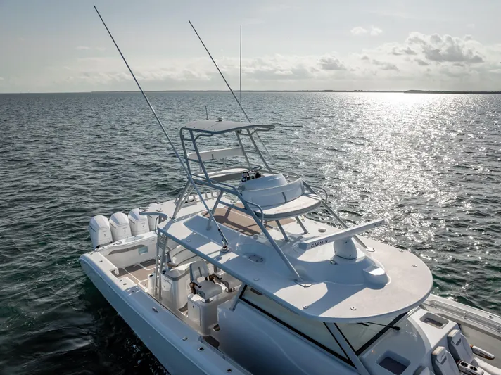  Yacht Photos Pics 2023 Yellowfin 54 boat on open water, featuring sleek design and multiple outboard engines.