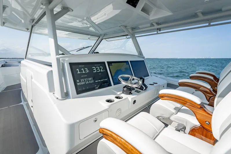  Yacht Photos Pics 2023 Yellowfin 54 boat cockpit with modern controls and luxurious seating on open water.