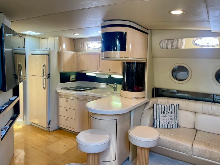 No Doubts IV Yacht Photos Pics Luxurious interior of a 1999 Sea Ray 500 Sundancer yacht with modern kitchen and seating area.