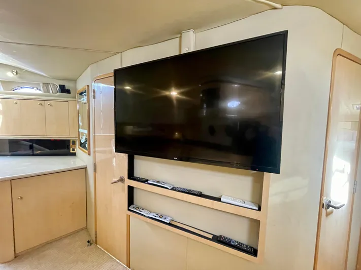 No Doubts IV Yacht Photos Pics Interior of 1999 Sea Ray 500 Sundancer with mounted TV and storage shelves.