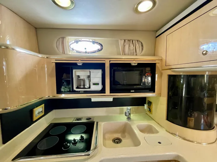 No Doubts IV Yacht Photos Pics 1999 Sea Ray 500 Sundancer yacht kitchen with stove, sink, microwave, and coffee maker.