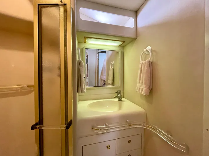 No Doubts IV Yacht Photos Pics 1999 Sea Ray 500 Sundancer bathroom with sink, mirror, and towel rack.