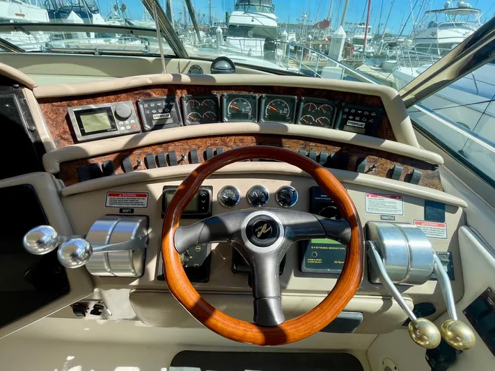 No Doubts IV Yacht Photos Pics 1999 Sea Ray 500 Sundancer helm with wooden steering wheel and control panel.
