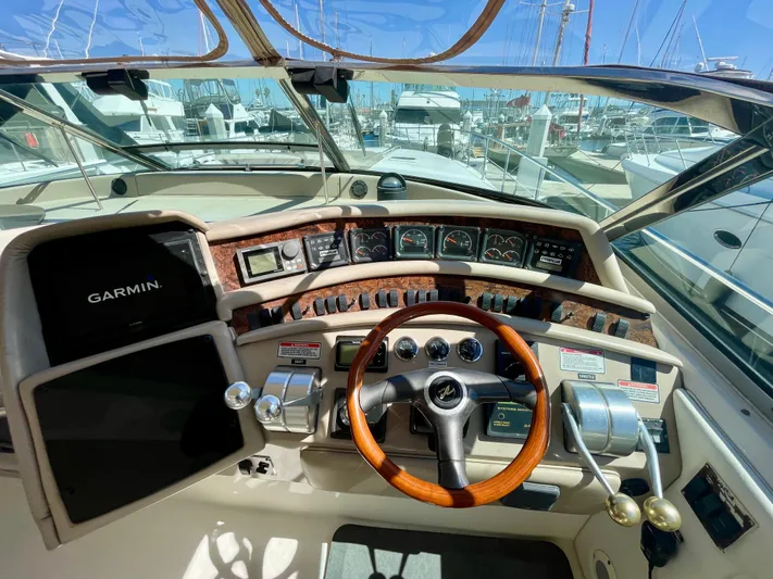No Doubts IV Yacht Photos Pics 1999 Sea Ray 500 Sundancer helm with Garmin navigation, wooden steering wheel, and marina view.