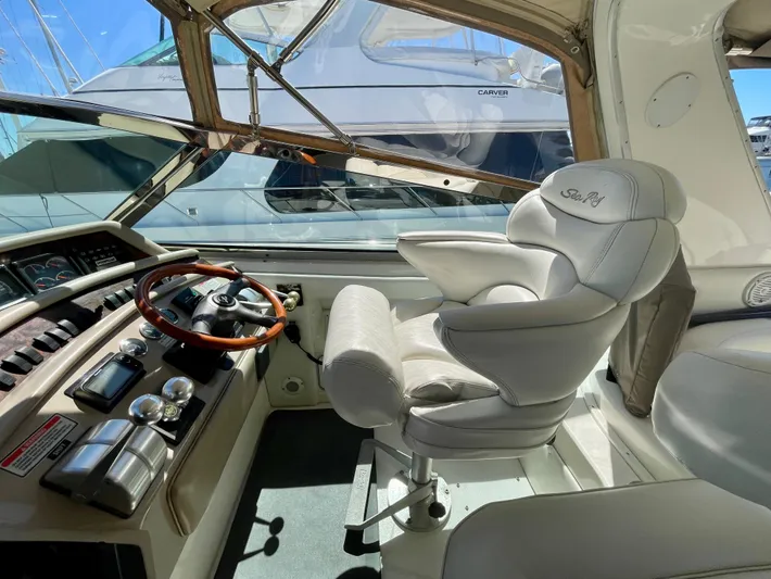 No Doubts IV Yacht Photos Pics 1999 Sea Ray 500 Sundancer helm with luxurious captain's chair and wooden steering wheel.