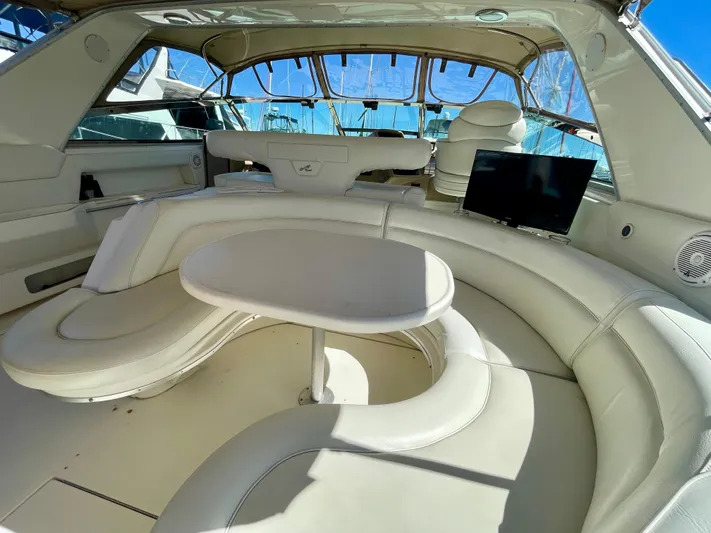 No Doubts IV Yacht Photos Pics Luxurious interior of 1999 Sea Ray 500 Sundancer yacht with curved seating and table.
