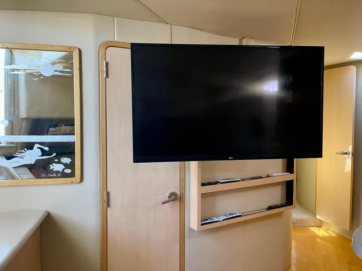 No Doubts IV Yacht Photos Pics Interior of 1999 Sea Ray 500 Sundancer with mounted TV and wooden cabinetry.