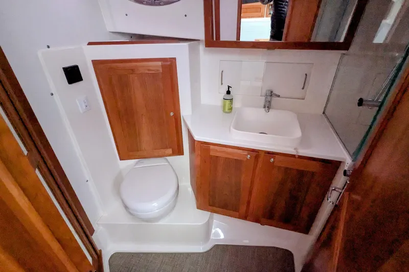  Yacht Photos Pics 2024 Back Cove 39O yacht bathroom with wooden cabinets, sink, and toilet.