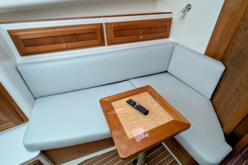  Yacht Photos Pics 2024 Back Cove 39O interior with cushioned seating and wooden table.