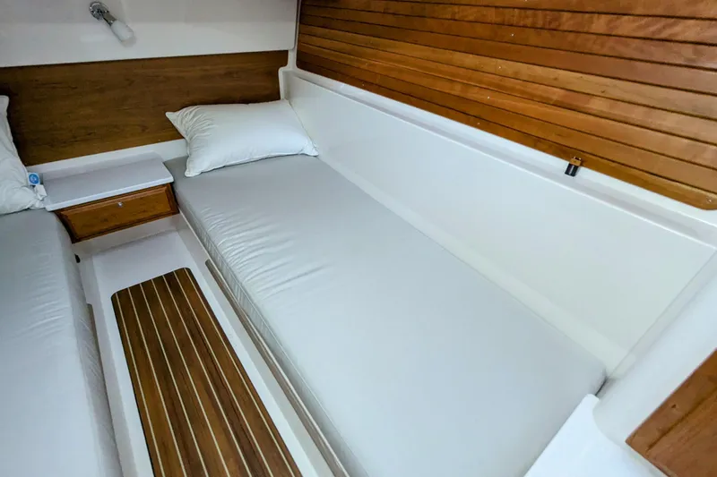  Yacht Photos Pics 2024 Back Cove 39O cabin interior with wooden accents and white bedding.