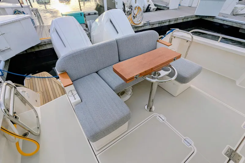  Yacht Photos Pics 2024 Back Cove 39O boat with cushioned seating and wooden table on deck.