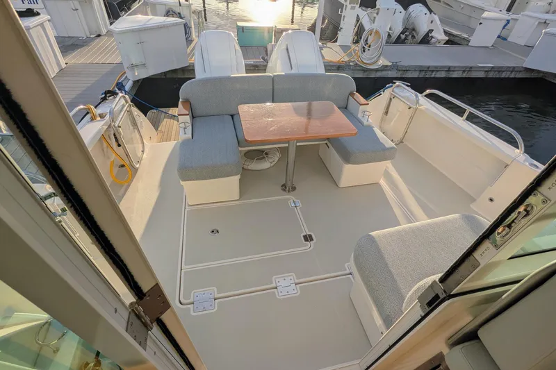  Yacht Photos Pics 2024 Back Cove 39O boat cockpit with seating and table, docked at marina.