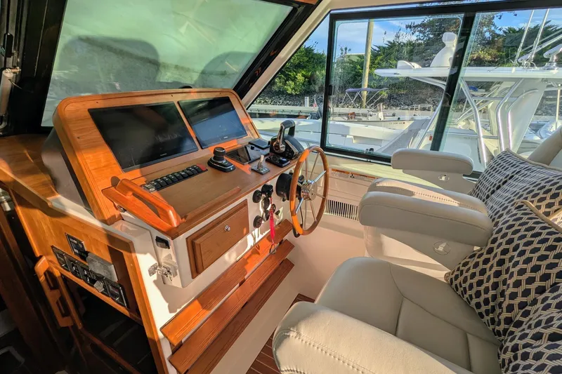  Yacht Photos Pics 2024 Back Cove 39O helm with modern controls, wooden accents, and comfortable seating.