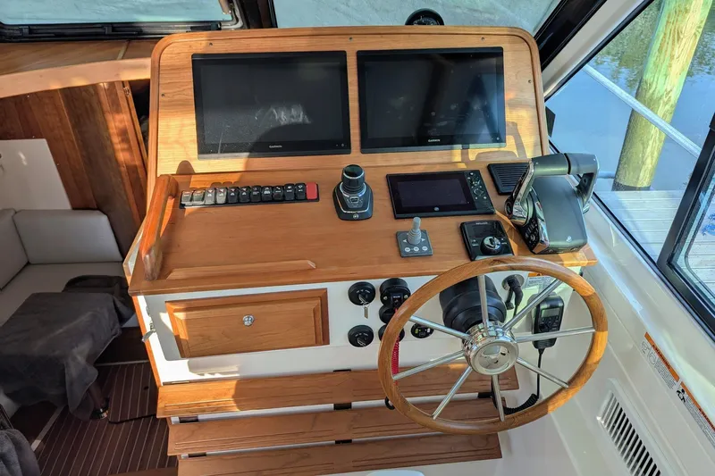  Yacht Photos Pics 2024 Back Cove 39O helm with dual screens, wooden wheel, and modern controls.