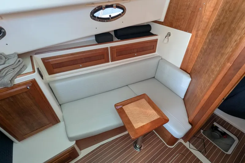  Yacht Photos Pics 2024 Back Cove 39O interior with wooden accents, white seating, and compact table.