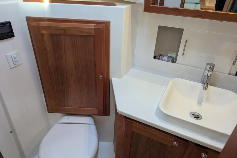  Yacht Photos Pics 2024 Back Cove 39O bathroom with wooden cabinetry, modern sink, and toilet.