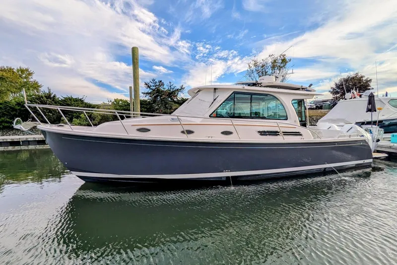  Yacht Photos Pics 2024 Back Cove 39O boat docked on calm water under a partly cloudy sky.