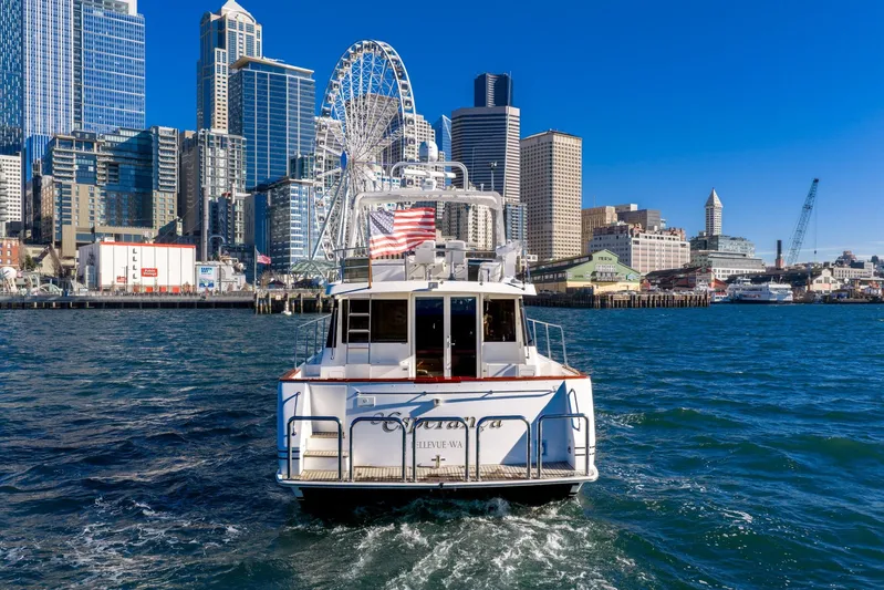 Esperanca Yacht Photos Pics 1998 West Bay 58 Sonship Pilothouse MY cruising near urban skyline and Ferris wheel.