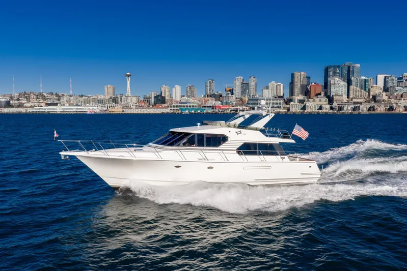 Esperanca Yacht Photos Pics 1998 West Bay 58 Sonship Pilothouse MY cruising near city skyline on sunny day.