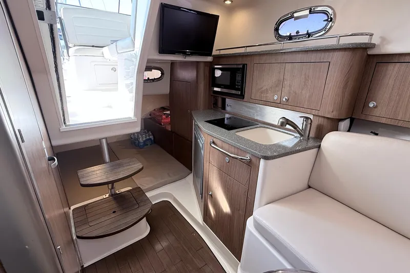  Yacht Photos Pics 2018 Boston Whaler 315 Conquest cabin interior with kitchenette and seating area.