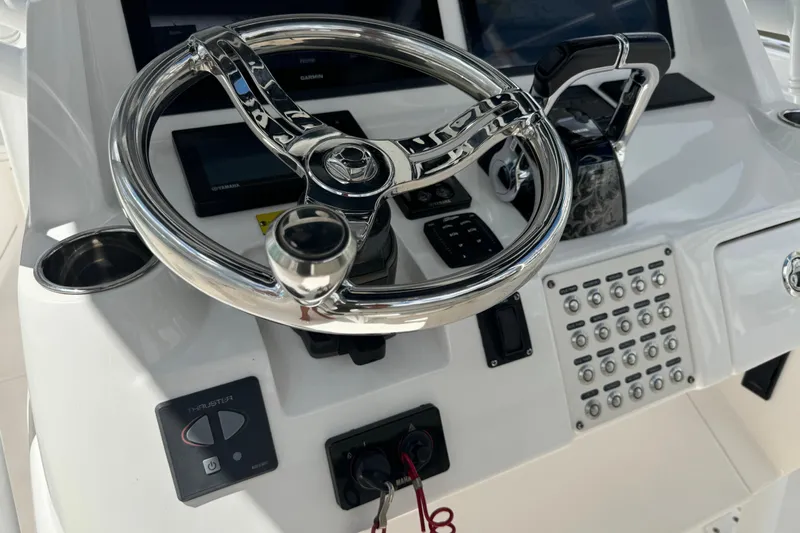  Yacht Photos Pics Control panel of 2019 Intrepid 345 Nomad FE boat with steering wheel and navigation controls.