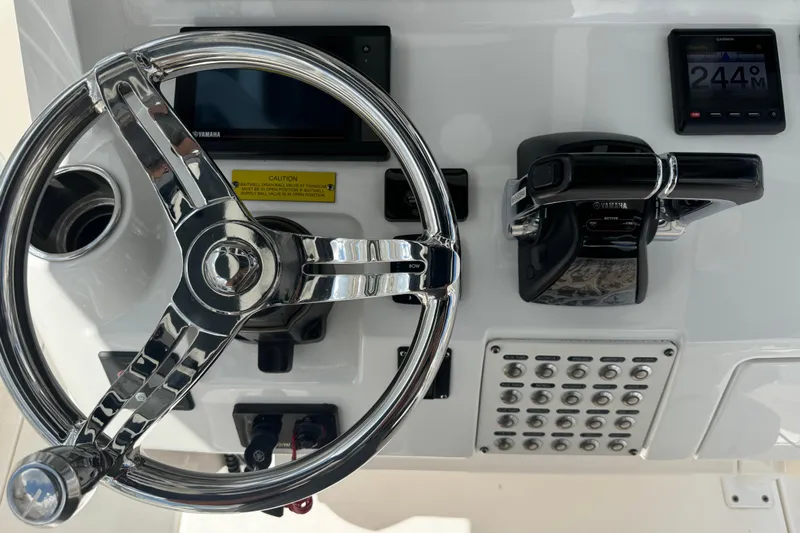  Yacht Photos Pics Control panel of 2019 Intrepid 345 Nomad FE boat with steering wheel and throttle.