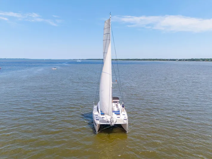 La Cura Yacht Photos Pics Sailing catamaran Privilege Series 5, 2015, on calm waters under a clear blue sky.