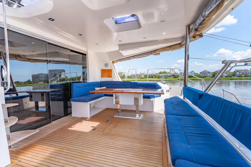 La Cura Yacht Photos Pics Spacious deck of 2015 Privilege Series 5 yacht with blue seating and wooden flooring.