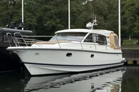 2019 Nimbus 365 Coupe' yacht docked by lush greenery.
