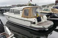 2019 Nimbus 365 Coupe' yacht docked in a marina, featuring a sleek design and Swedish flag.