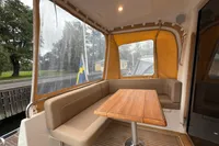 2019 Nimbus 365 Coupe interior with cozy seating and wooden table, featuring a scenic view.