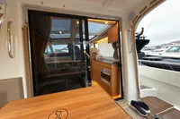 Interior view of 2019 Nimbus 365 Coupe' yacht with wooden cabinetry and seating area.