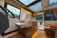 Interior of 2019 Nimbus 365 Coupe, featuring helm, seating, and panoramic windows.