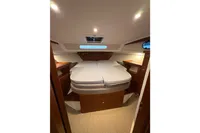 2019 Nimbus 365 Coupe' cabin interior with cozy bed and wooden furnishings.