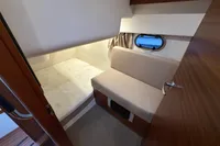 2019 Nimbus 365 Coupe cabin interior with bed, seating, and porthole window.